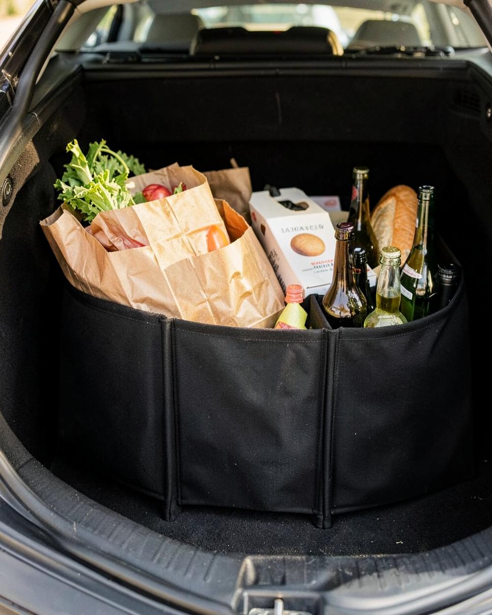 STOWVELA. Trunk Organizer holding paper grocery bags and bottles in a trunk